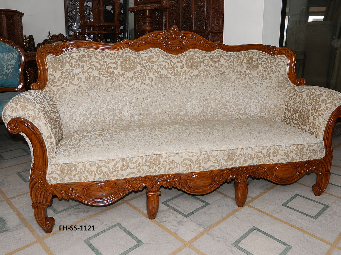 Elegant handcrafted wooden sofa with intricate carvings, premium beige floral upholstery, rolled arms, and a polished solid wood frame.