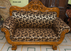 Luxury handcrafted wooden loveseat featuring ornate floral carvings, rolled armrests, floral-pattern upholstery, and a classic royal-inspired design.