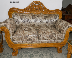 Elegant handcrafted wooden loveseat with intricate floral carvings, paisley-pattern upholstery, rolled arms, and a polished natural wood finish.