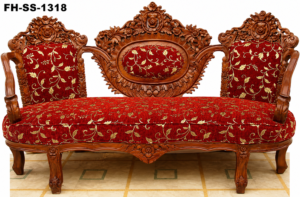 Elegant handcrafted wooden chaise lounge sofa with intricate floral carvings, luxurious red floral upholstery, and an ornamental royal backrest.