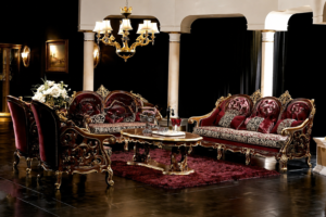 Luxury royal burgundy carved wooden sofa set with matching armchairs, premium upholstery, elegant center table, and classic palace-inspired living room décor.