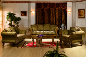 Elegant olive green classic wooden sofa set featuring a three-seater sofa, matching armchairs, premium upholstered cushions, carved wooden coffee table, and timeless living room décor.