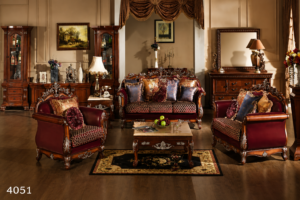 Luxurious royal mahogany living room sofa set with handcrafted carved wooden frame, rich burgundy upholstery, decorative cushions, matching armchairs, and elegant coffee table in a classic interior.