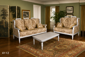 Elegant French country style sofa set with antique white carved wooden frames, floral upholstered fabric, matching seating, decorative cushions, and a coordinating coffee table in a sophisticated living room.