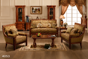 Elegant classic living room sofa set featuring premium wooden frames, olive floral upholstery, matching armchairs, decorative cushions, and a handcrafted wooden coffee table in a sophisticated interior.