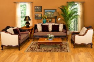 Elegant classic sofa set featuring a handcrafted walnut-finished solid wood frame, beige premium upholstery, decorative accent cushions, matching armchairs, and a wooden center table in a warm contemporary living room.