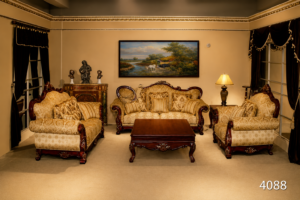 Luxury handcrafted wooden sofa set with premium beige upholstery, carved hardwood frame, plush cushions, and matching center table in a traditional living room.