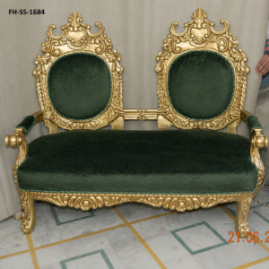 A luxurious handcrafted loveseat featuring an intricately carved solid wood frame with an elegant antique gold finish and premium dark green velvet upholstery. Designed with twin royal backrests, ornate floral carvings, and plush seating, this statement piece brings timeless European elegance to luxury homes, hotels, villas, and palace-inspired interiors.
