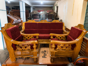 A beautifully crafted Premium Solid Wood Sofa Set (3+1+1) featuring a durable solid wood frame with elegant handcrafted carvings and rich maroon fabric upholstery. This complete set includes one spacious 3-seater sofa and two matching single-seater armchairs, offering a perfect combination of traditional craftsmanship, comfort, and durability for living rooms, lounges, offices, hotels, and reception spaces.