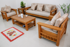 A beautifully crafted Classic Solid Wood Living Room Sofa Set featuring a premium natural wood finish with soft beige upholstered cushions. This elegant furniture set includes a spacious 3-seater sofa, two matching single-seater chairs, a center table, and a side table. Its timeless wooden craftsmanship and clean contemporary design make it a perfect addition to modern and traditional interiors alike.