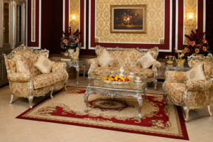 Luxury silver carved wooden sofa set with premium floral upholstery, ornate coffee table, and classic European-style living room furniture.