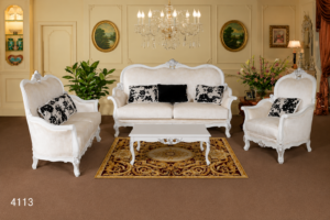 Elegant white luxury wooden sofa set with hand-carved frame, premium upholstered seating, decorative black accent cushions, and matching center table.