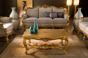 Luxury gold carved wooden sofa set with premium beige upholstery, ornate coffee table, and classic European-style living room furniture.