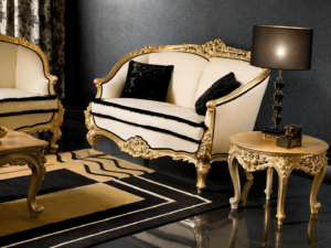 Luxury cream upholstered carved wooden sofa set with antique gold finish, black accent cushions, and classic European-style living room furniture.