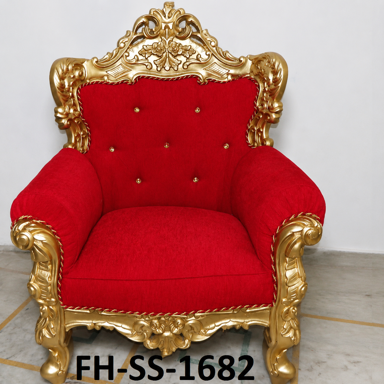 A luxurious handcrafted royal accent armchair featuring a solid wood frame with an antique gold finish, plush ruby red upholstery, crystal button tufting, and intricate hand-carved detailing. Its elegant silhouette and regal craftsmanship make it an eye-catching addition to luxury living rooms, hotel lobbies, lounges, and palace-inspired interiors.